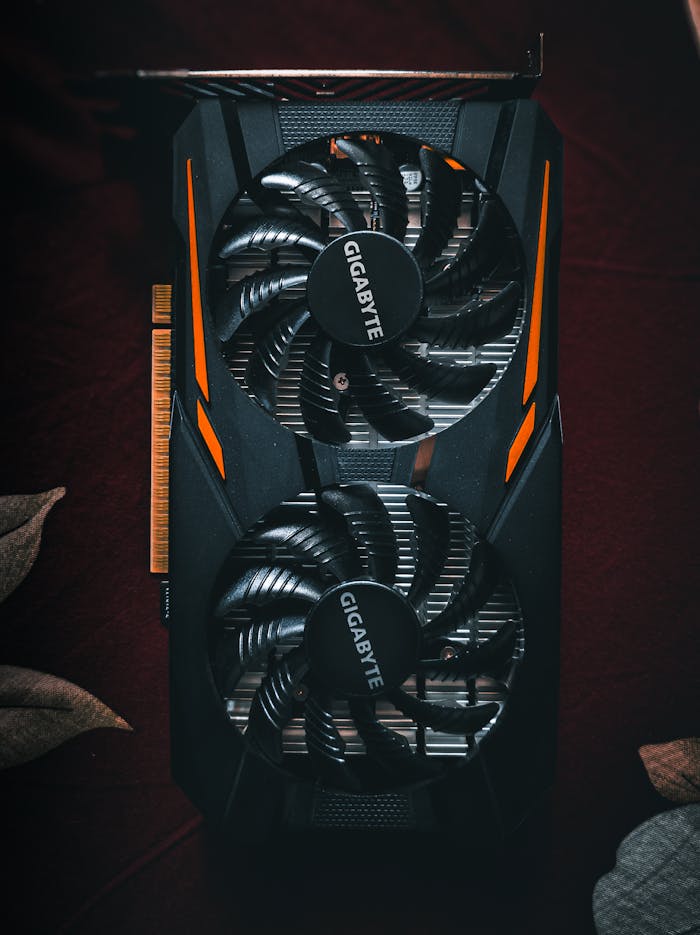 Detailed close-up of a black and orange graphic card with cooling fans.